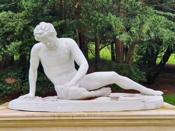 White statue against trees in park