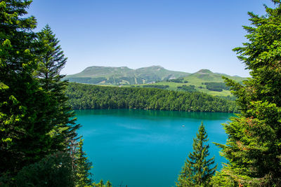 Scenic view of lake and mountains against clear blue sky