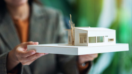 An architect holding and working on an architecture house model in the office