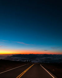 Empty road against sky during sunset