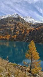 Scenic view of lake by snowcapped mountains against sky