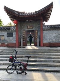 Rear view of man on bicycle outside building