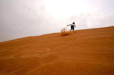 Low angle view of boy running in desert