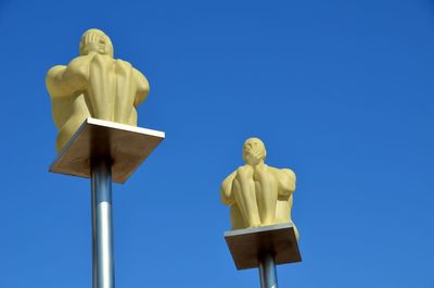Low angle view of statue against clear blue sky