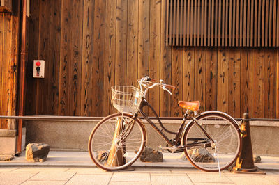 Bicycle parked on sidewalk against building