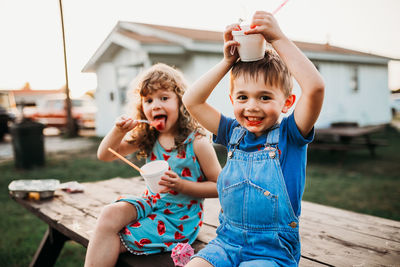 Close up of two young kids eating snow cones in summer