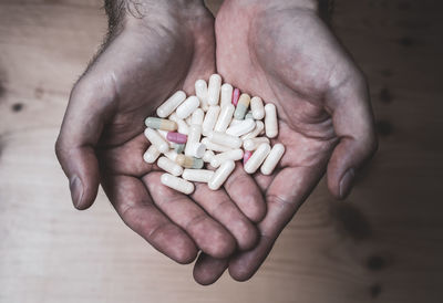 Close-up of hand holding medicines over table