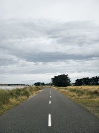 Road amidst green landscape against sky