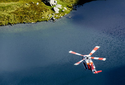 High angle view of helicopter flying over lake