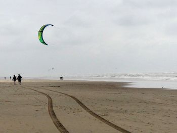 People on beach against sky