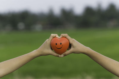 Close-up of hand holding leaf against blurred background