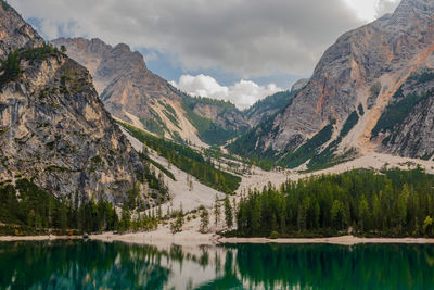 Scenic view of lake by mountains against sky