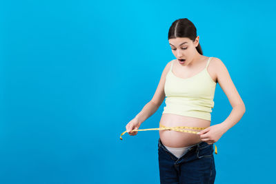 Woman standing against blue background