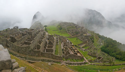 High angle view of historic machu picchu ruins in foggy weather