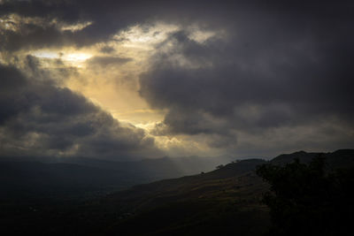 Scenic view of dramatic sky over silhouette landscape