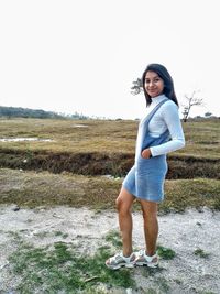 Portrait of young woman standing on field