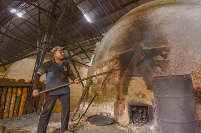 Low angle view of man working in machine