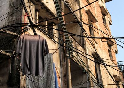 Low angle view of clothes hanging on building against sky