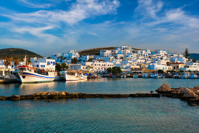 Scenic view of sea by townscape against sky