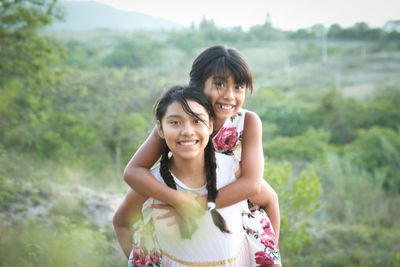 Two pretty girls hugging each other and smiling 