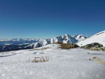 Scenic view of snowcapped mountains against clear blue sky