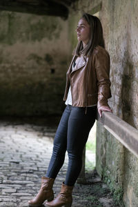 Portrait of young woman standing on footpath