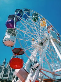 Low angle view of ferris wheel against clear blue sky