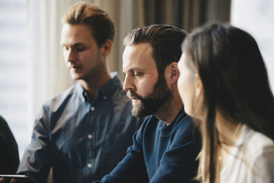 Businessman sitting with colleagues in office