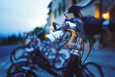 Close-up of bicycles parked on road against sky