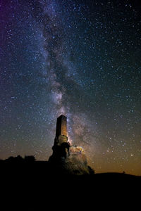 Low angle view of historical building against star field at night 