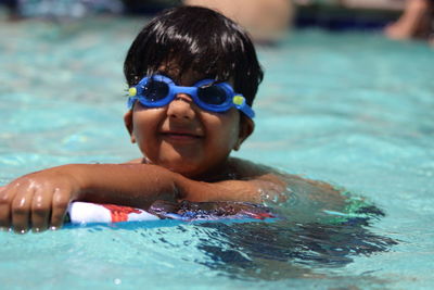 Portrait of shirtless boy swimming in pool