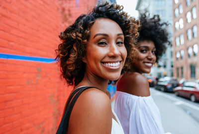 Portrait of smiling friends standing in city