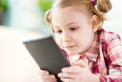 Close-up of girl using digital tablet