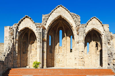 Low angle view of historical building against clear blue sky