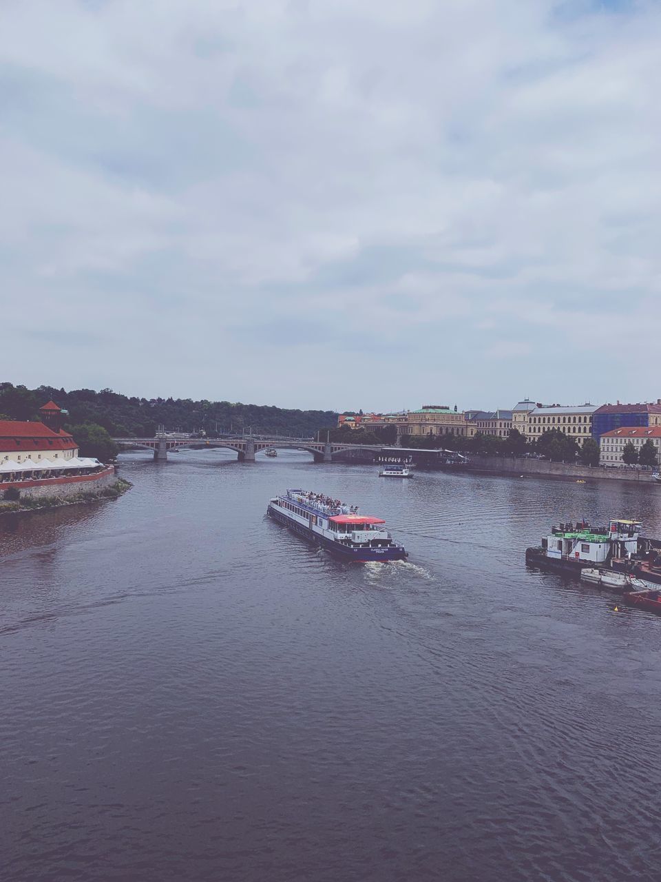 BOAT IN RIVER AGAINST SKY IN CITY