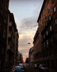 Cars on road against cloudy sky