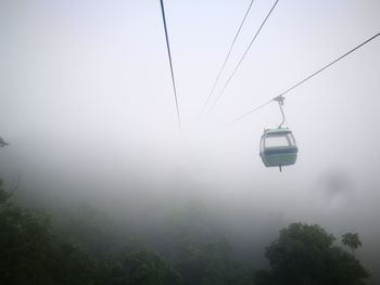 Overhead cable car against sky during foggy weather