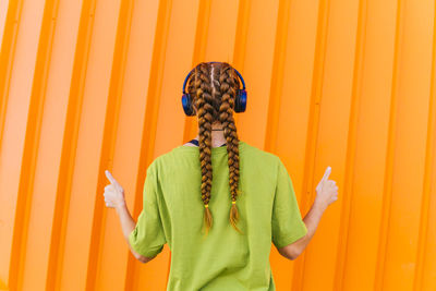 Mid section of woman standing against yellow background