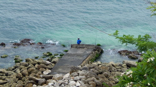 Rear view of a man fishing on sea