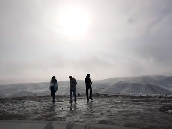 Rear view of men on mountain road against sky