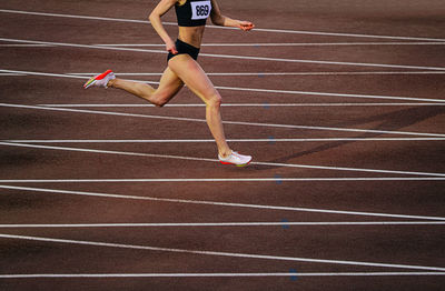 Full length of woman running on playing field