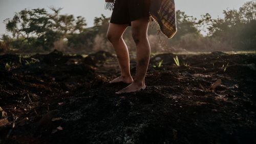 Low section of woman standing on field