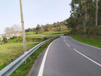 Road passing through landscape against clear sky