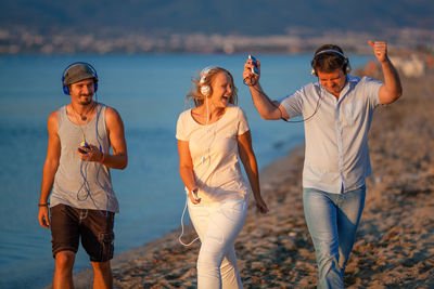 Cheerful friends walking at beach