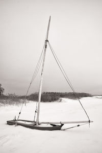 Sailboat on snow covered land against sky