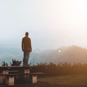 Rear view of man standing against mountain 