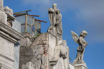 Low angle view of angel statue against historic building