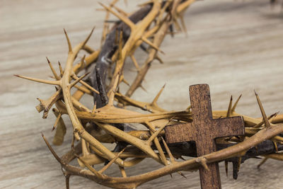 A christian cross with thorn crown on a wooden table.