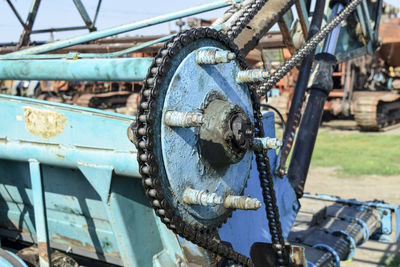 Close-up of rusty machinery on field