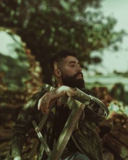 Portrait of young man looking away in forest